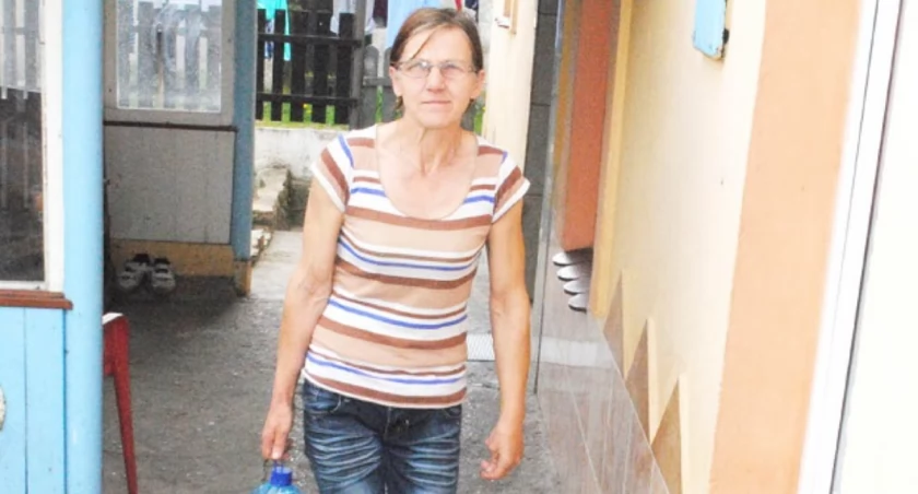 Kazimiera Bazyl po kilka razy dziennie nosi plastikowe butle wypełnione wodą potrzebną do celów spożywczych oraz do mycia i spłukiwania toalety w mieszkaniu matki, która po udarze i wylewie od miesięcy przykuta jest do łóżka. Woda bieżąca w mieszkaniu została już na długo wcześniej odcięta przez spółdzielnię mieszkaniową z uwagi na zadłużenie ciążące na lokalu. 	fot. Karol Gapiński