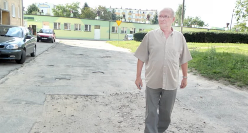 Jan Pluskota nie ma wątpliwości, że ulica przed blokiem przy Lotników 15 w Barcinie jest w najgorszym stanie na całym osiedlu. Trudno byłoby zresztą znaleźć gorszą nawierzchnię i bardziej podziurawioną na jakiejkolwiek innej ulicy w całym mieście.  fot. Karol Gapiński