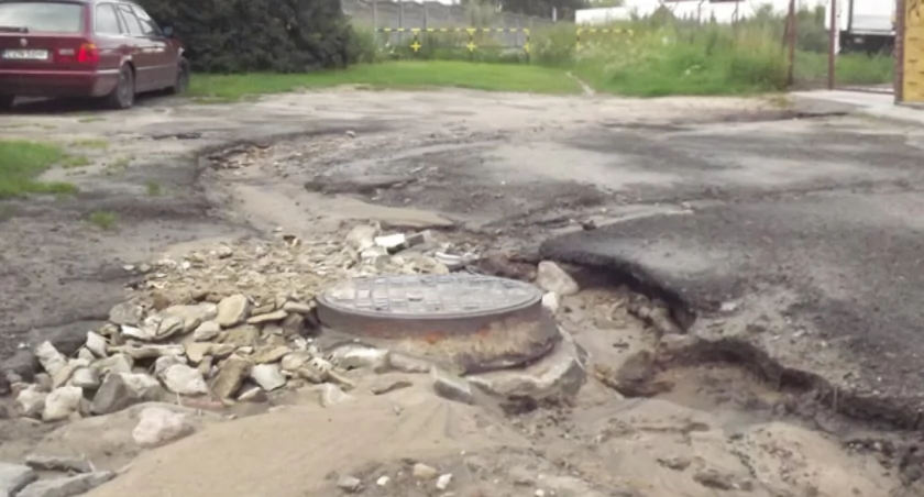 Po kolejnych ulewach woda wydrążyła sobie w ulicy Bocznej koryto i podmyła studnie kanalizacji sanitarnej. Z prawej strony wybrukowane parkingi, z których na ulicę spływa woda. fot. Bartosz Woźniak