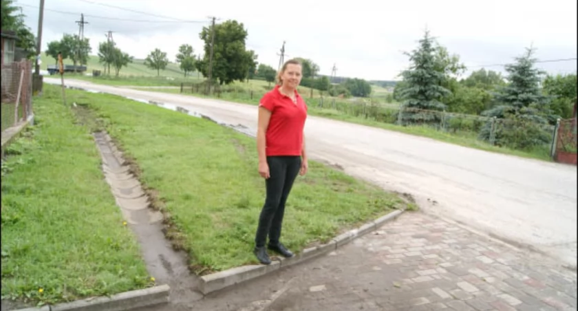 Teresa Kubalak pokazuje nachylenie drogi i wjazd na posesję dzień po zalaniu fot. Arkadiusz Majszak