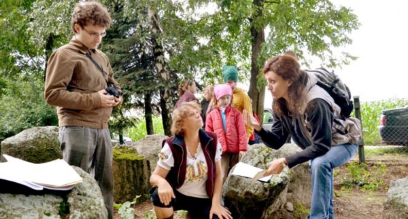 Danuta Wesołowska prezentuje archeologom zgromadzone mapy i dokumenty dotyczące kurhanu. Na zdjęciu z tyłu wolontariusze gotowi w każdej chwili zrobić porządek w miejscu zabytku. fot. Magdalena Kruszka