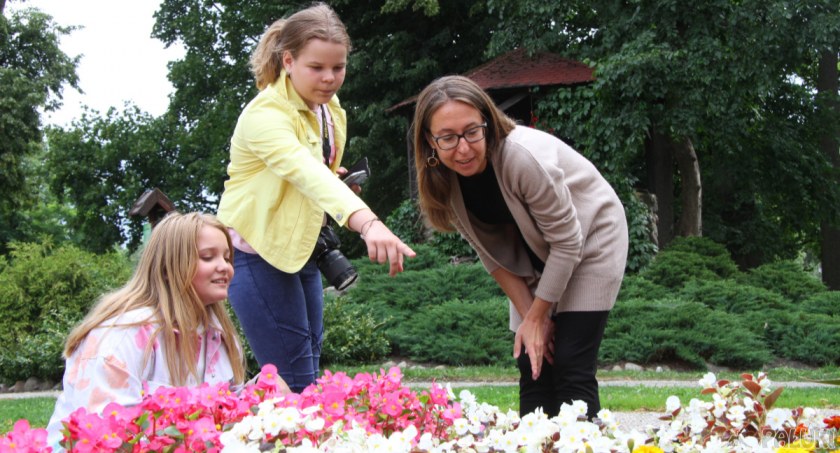 Liliana Kokoszka (pierwsza z lewej) i Olga Małecka (w środku) słuchają rad Joanny Bejmy dotyczących tego jak zrobić ładne zdjęcie kwiatom fot. Remigiusz Konieczka
