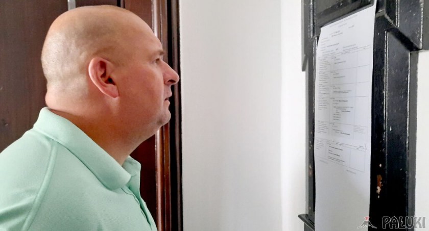 Artur Krajewski czyta wokandę przed wejściem na salę rozpraw fot. Remigiusz Konieczka