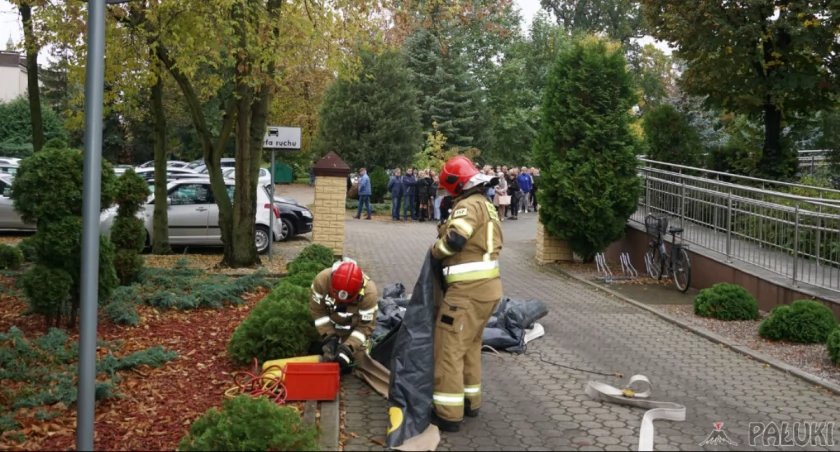 Strażacy rozkładają namiot do dekontaminacji. Z parkingu przyglądają się ich poczynaniom ewakuowani przed chwilą pracownicy starostwa. fot. Karol Gapiński