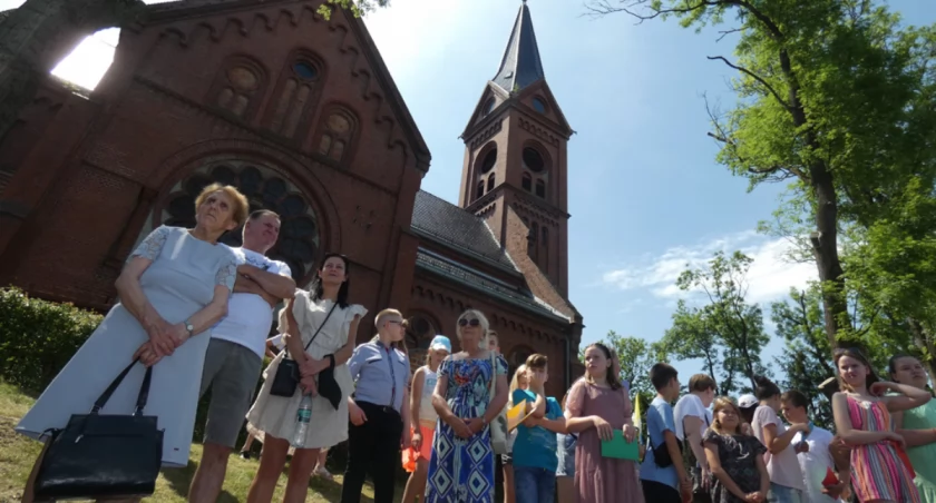 Kościół pw. św. Jakuba Większego w Barcinie to monumentalny obiekt w stylu neogotyckim. Parafianie starają się wspomóc jego remont organizując od kilku lat festyny parafialne ze zbiórkami na remont. To zdjęcie z festynu w 2022 r. Za plecami ludzi widać akurat fragment dachu, który teraz został uszkodzony przez petardę. fot. Karol Gapiński