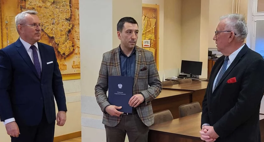 Rafał Heftowicz otrzymał akt powołania na stanowisko pełniącego funkcję burmistrza kcyni. Po lewej - wicewojewoda Piotr Hemmerling, po prawej - przewodniczący Rady Miejskiej w Kcyni fot. Ewa Hałas