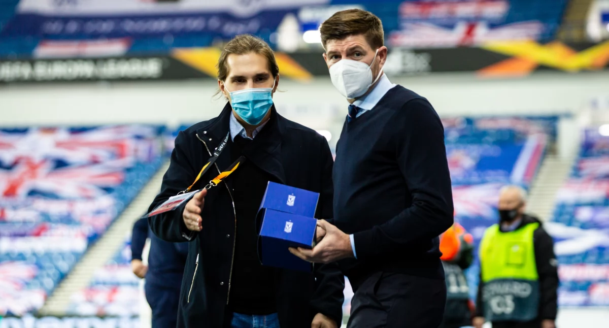Pracownik Lecha Poznań Szymon Goc na Ibrox Park wręcza Stevenowi Gerrardowi rogale świętomarcińskie. fot. z archiwum Szymona Goca